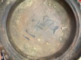 a metal bowl on a rug with a horse drawn on it