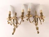 quatre appliques murales à quatre lumières, avec une finition dorée et des abat-jours en verre blanc