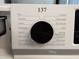 a close up of a washing machine with a button on it