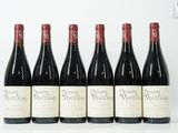 six bouteilles de vin sont alignées sur une table