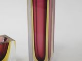 two vases sitting next to each other on a white surface