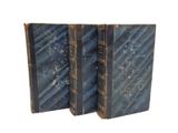 two old books sitting on top of each other on a white surface