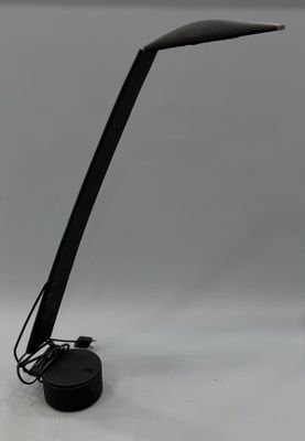 une photo d'une lampe de bureau noire posée sur une surface blanche