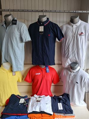 a lot of men ' s polo shirts on display in a store