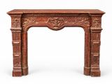 un encadrement de cheminée ancien orné d'un motif sculpté sur le dessus