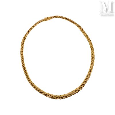 gros plan d'un collier en or sur fond blanc