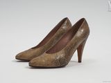 une paire d'escarpins en peau de serpent marron sur fond blanc