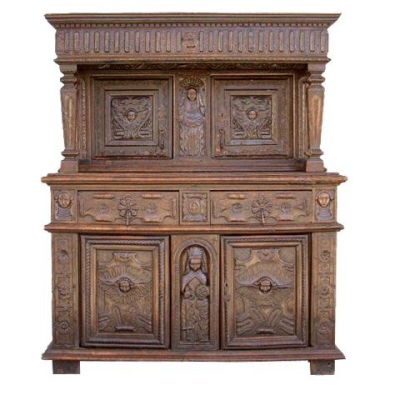 une vieille armoire en bois ornée de sculptures sur la façade
