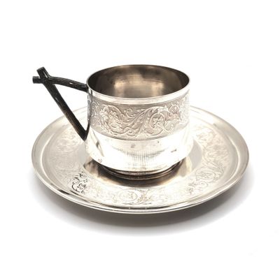 a silver cup and saucer on a silver plate