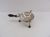 a silver plated teapot with a black handle on a white surface