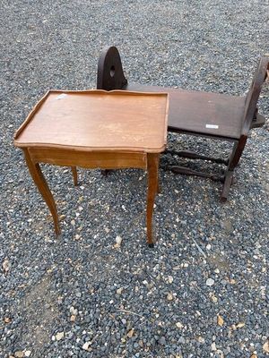a small table and a chair sitting on the gravel