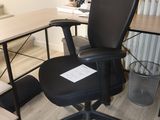 a black office chair sitting in front of a computer desk
