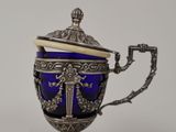 une théière ancienne en argent et verre bleu, posée sur un socle