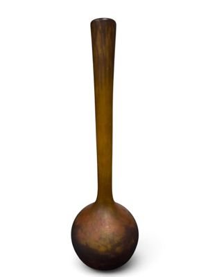 un vase brun posé sur une surface blanche