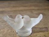 a glass bird that is sitting on a wooden table