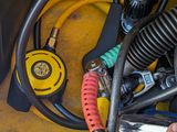 a person holding a tool in their hand near a bunch of hoses
