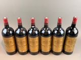 six bottles of red wine lined up in a row on a table