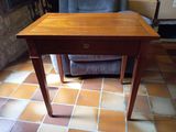 a small wooden table with a drawer on top of it
