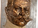 une plaque en bronze représentant un homme avec une moustache et une barbichette