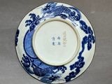a close up of a blue and white plate with a dragon on it