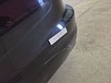 a sticker on the back of a car that is parked on the side of the road