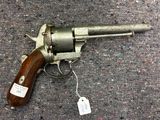 un pistolet posé par terre, avec une étiquette de prix dessus