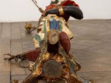 a statue of a man riding a horse on a wooden floor