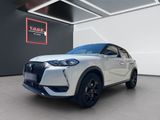 a white suv parked in a showroom with a red sign above it
