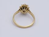 a gold ring with a flower design on the side and a diamond in the middle