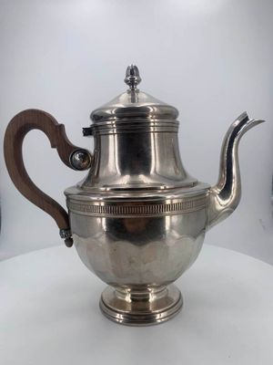 silver plated teapot with wooden handle on a white table
