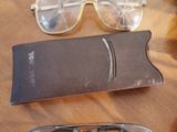 a pair of glasses sitting on a table next to a pair of glasses