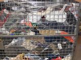 a metal cage filled with lots of clothes in a warehouse