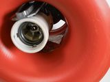 underside view of a red skateboard wheel with a white hub