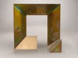 une sculpture métallique posée sur une surface blanche