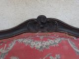 a red couch with a floral pattern on it