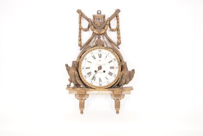 une horloge posée sur une étagère, sur fond blanc