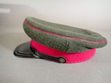 a green hat with a pink band and a cell phone
