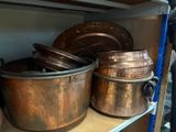 many pots and pans on a shelf in the kitchen
