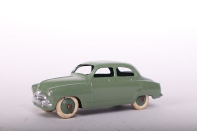 a green toy car that is sitting on a white surface