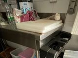 a kitchen with a sink and a counter with a mattress on it