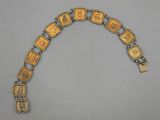 a close up of a gold bracelet with squares on it