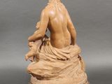 an image of a statue of a woman sitting on top of a table