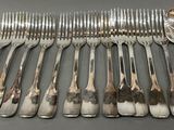 many forks and spoons laid out on the table