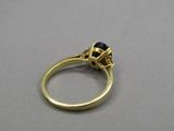 gros plan d'une bague en or avec une pierre noire