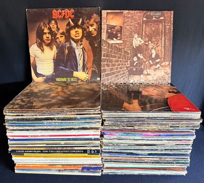 une pile de disques vinyles posée sur une table bleue