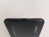 the back of a black cell phone with a broken screen