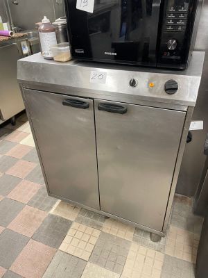 a microwave sitting on top of a stainless steel cabinet in a kitchen
