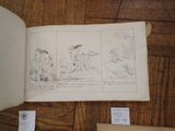 an open book on the floor with drawings on it