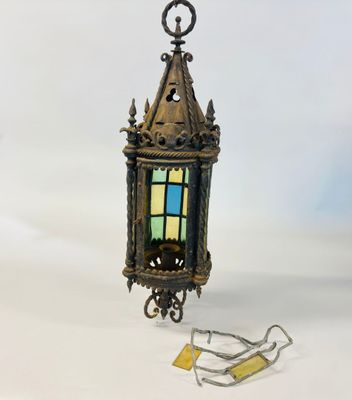 an old brass lantern with a stained glass window on a chain