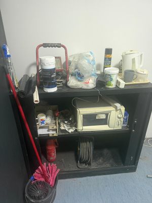 une étagère sur laquelle se trouvent un micro-ondes, un four à micro-ondes et une serpillière